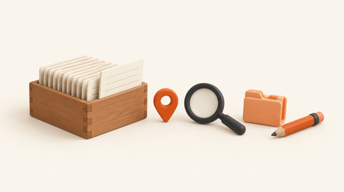 Illustration of a wooden card index box with one card pulled out, a map pin, a magnifying glass, a folder and a pencil