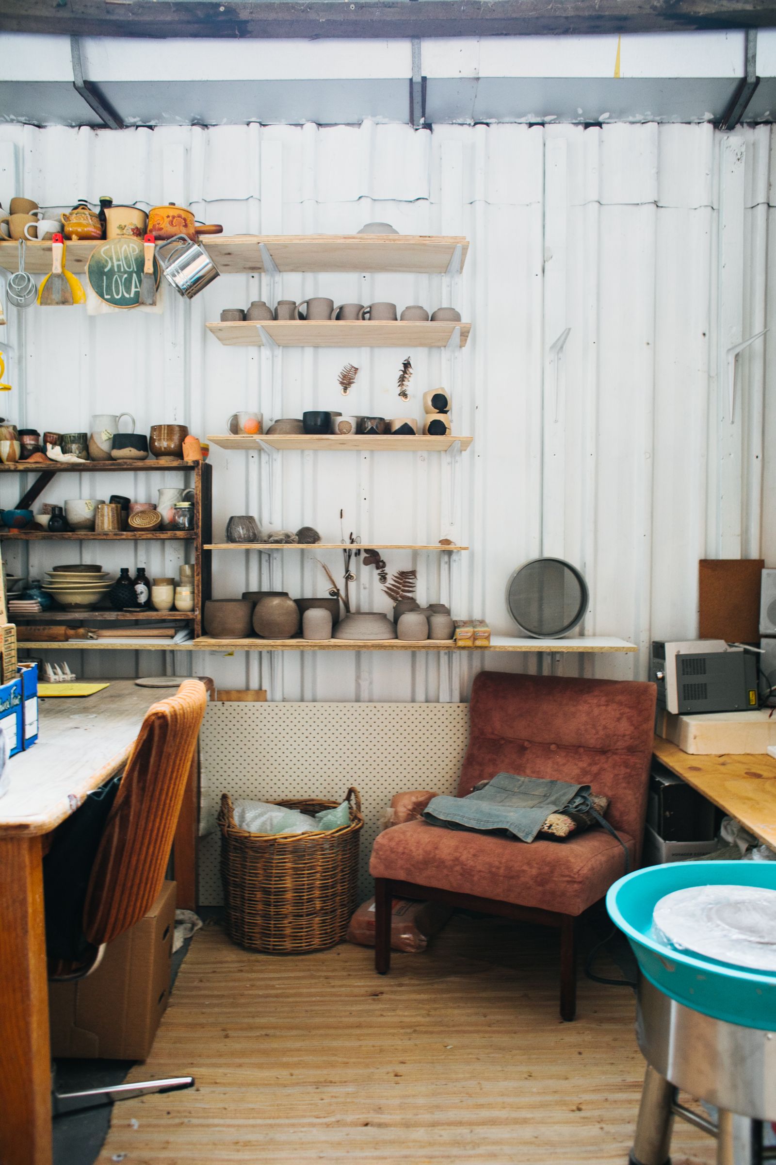 A small workshop with shelves of handmade ceramics